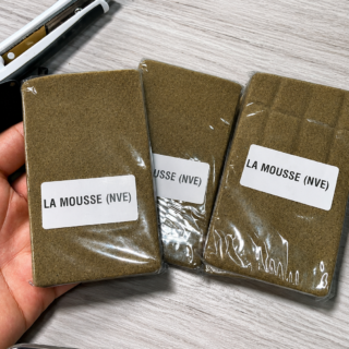 La Mousse (NVE) Hash packages in clear sealed wrapping with white product labels arranged on a light wood surface